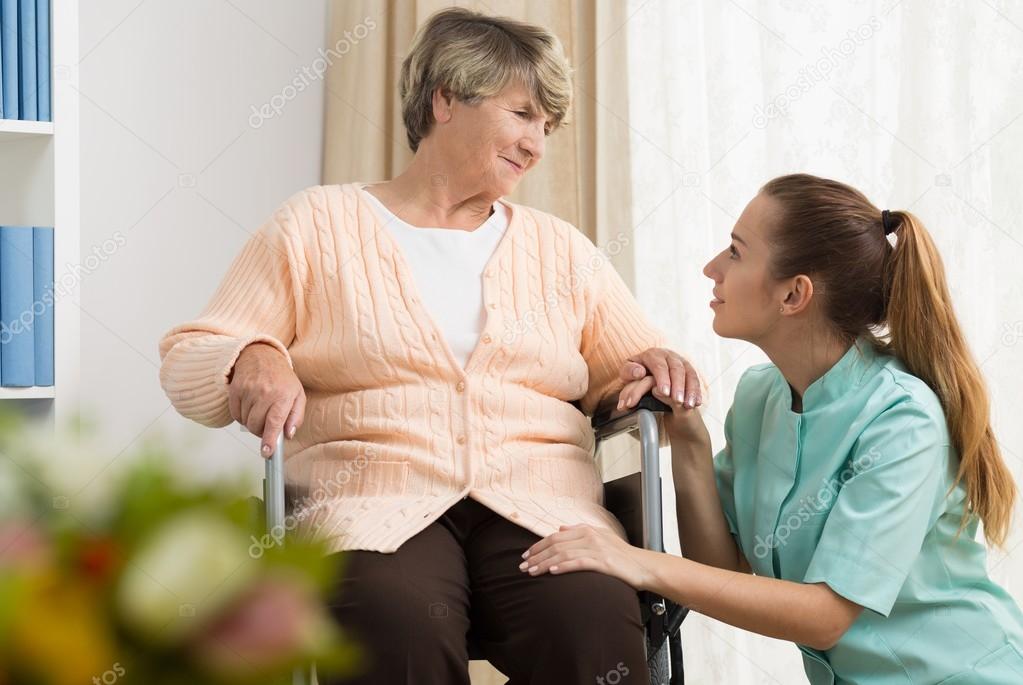 Seniorin hält die Hand einer Betreuerin in vertrauensvoller Atmosphäre.