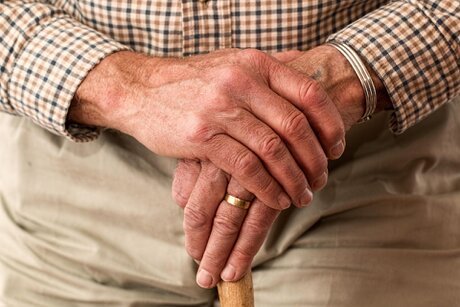 Mitarbeiterin begleitet Senioren sicher beim Gehen